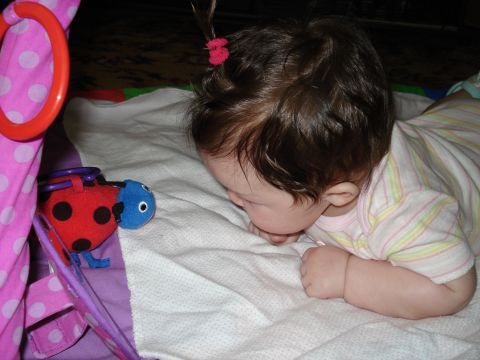 2000 Ford Crown Victoria - A baby lies on a playmat, reaching out to touch a ladybug toy.