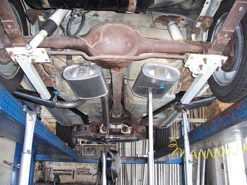 1978 Ford Mustang II - The underside of a vehicle is visible, with its rear axle and dual exhaust system prominently displayed on a car lift.
