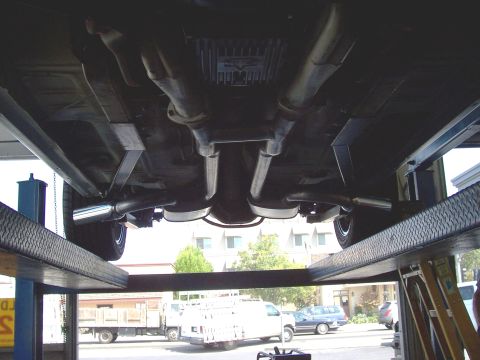 1978 Ford Mustang II - The undercarriage of a 1978 Ford Mustang II is visible as it is raised on a service lift.