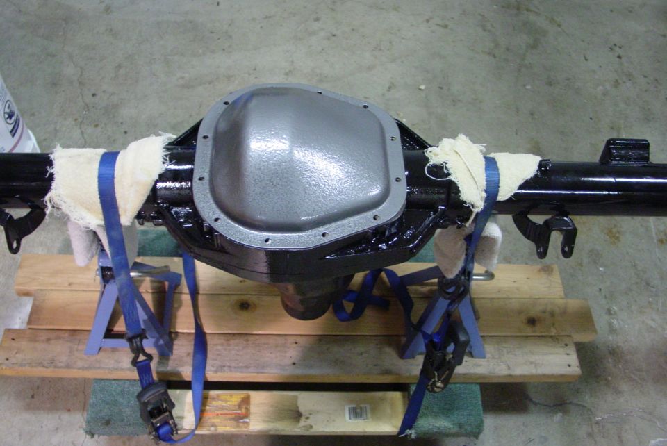 Ford rear axle assembly with differential cover, supported by jack stands and straps