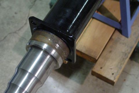 1993 Ford Bronco - A close-up view of a vehicle axle component with a black flange, resting on wooden planks.