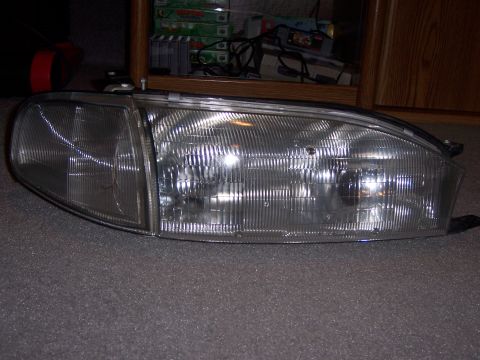 1987 Volkswagen Golf - A single headlight assembly is shown, detached from a vehicle and placed indoors.