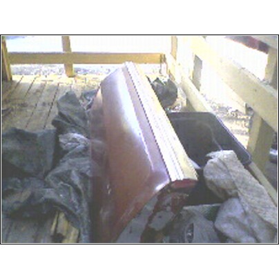1973 Ford Ranchero - A red tailgate with a yellow stripe is seen resting on wooden planks.