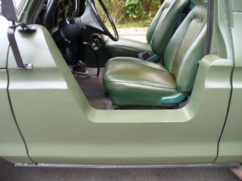 1978 Ford Bronco - The interior of a 1978 Ford Bronco features green two-tone seats and a light green exterior paint visible on the door frame.