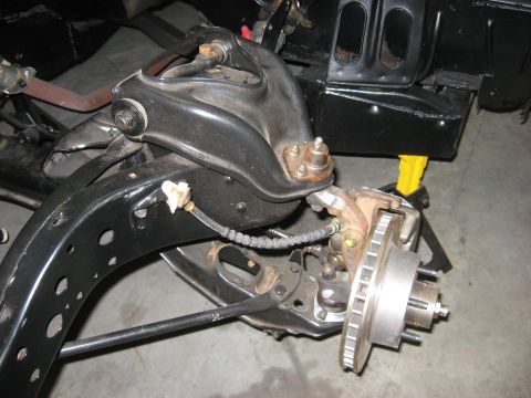 1965 Ford Galaxie - Close-up view of a vehicle's front suspension system and brake assembly.