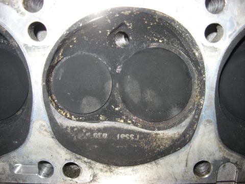 1965 Ford Galaxie - Close-up of an engine cylinder head showing carbon deposits and stamped markings.