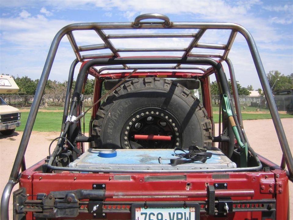 Rear of red Suzuki Samurai with tube roll cage, spare tire, and Arizona plate