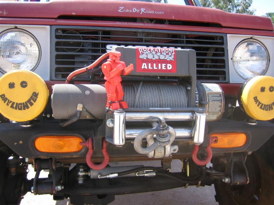 1987 Suzuki Samurai front end with yellow Daylighter lights, red winch, and "Zuks Off Road.com" sticker