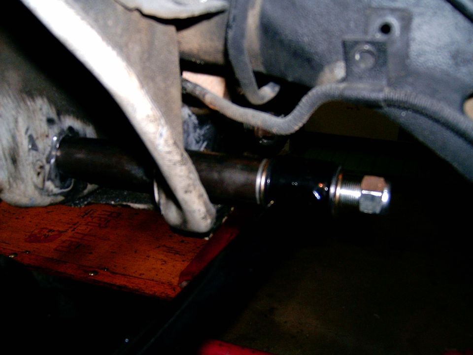 Close-up of a black automotive suspension part with a silver nut and bolt