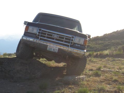 1988 Ford Bronco - This 1988 Ford Bronco navigates a challenging off-road course, its 4x4 capabilities on a steep incline.