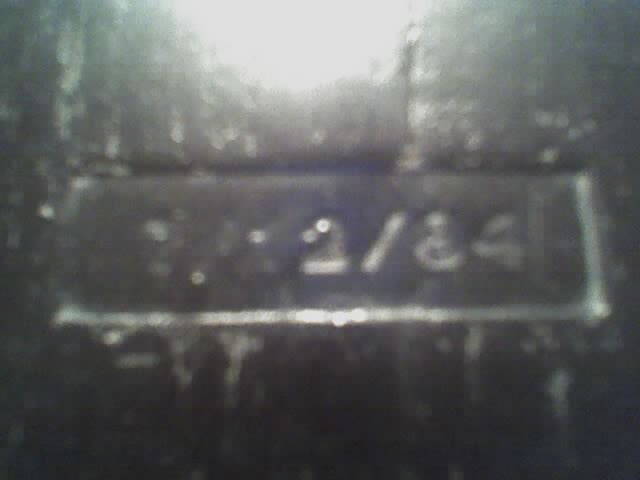 Close-up of a metal plate with "11-2/84" stamped on it