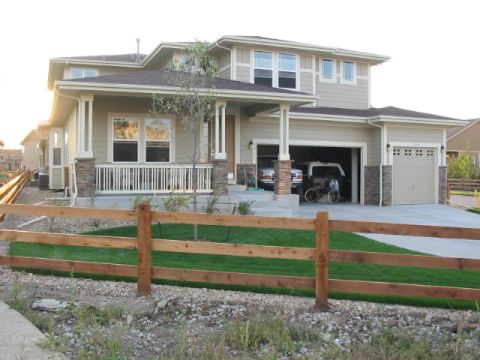 1995 Ford Bronco - A suburban house with a well-maintained lawn and a split-rail fence in the foreground.