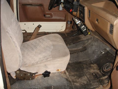 1989 Ford Bronco - Interior view of a vehicle with tan patterned seats and a brown dashboard.