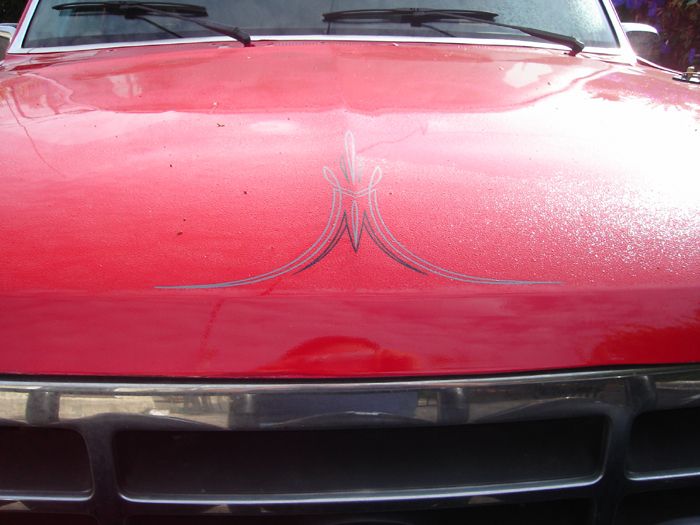 Red truck hood with silver pinstripes and chrome grille