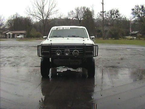 1984 Ford Bronco - This white Ford Bronco features a prominent bull bar and a 'For Sale' sign on the windshield, suggesting it is available for purchase.