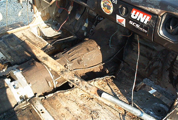 Gutted truck cab interior exposing transmission and transfer case with decals on the dash