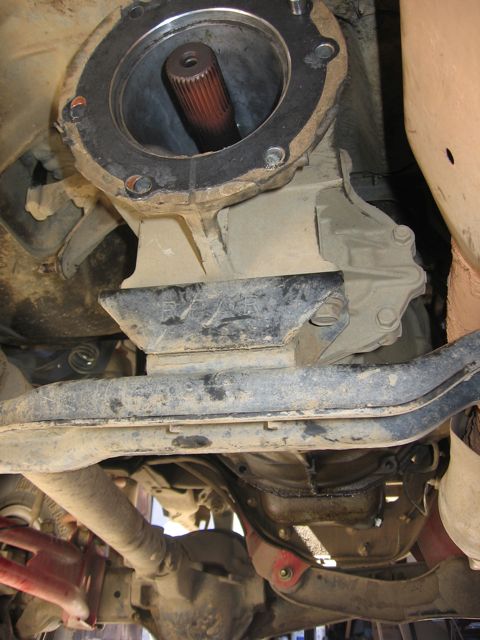1989 Ford Bronco - Underside view of a vehicle's driveshaft entering the transmission housing.