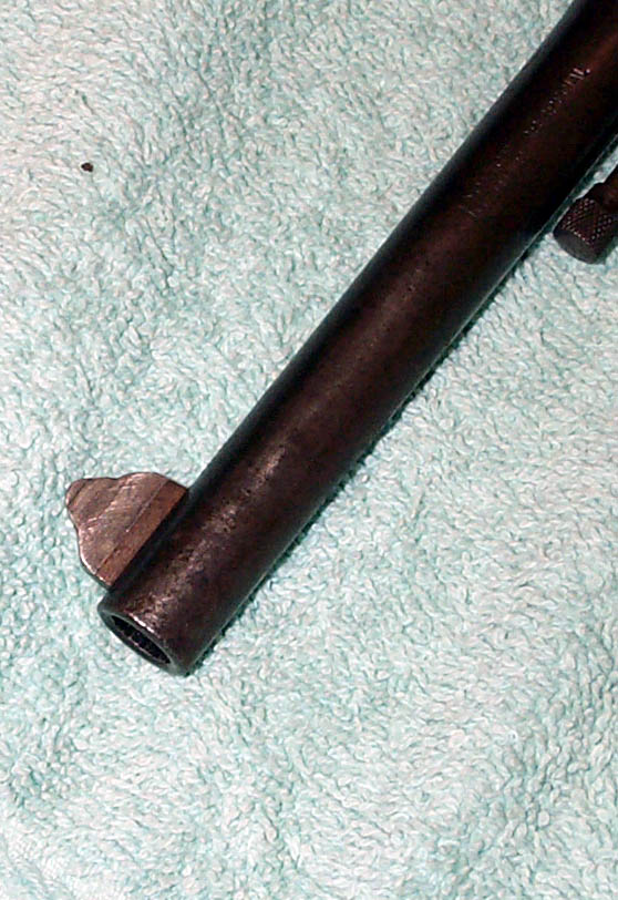 Close-up of a firearm barrel resting on a textured cloth