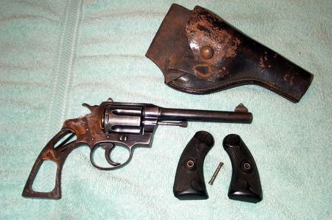 1996 Ford Bronco - A vintage revolver, its grips removed, lies next to a weathered holster.
