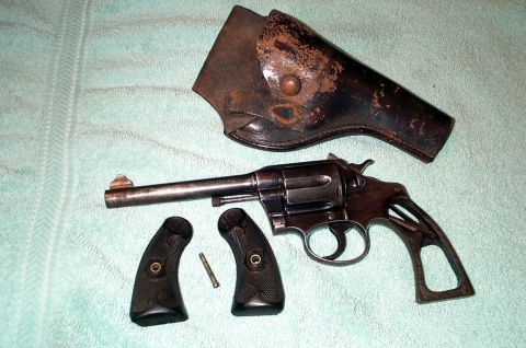 1996 Ford Bronco - A disassembled revolver with its holster and grips laid out on a textured surface.