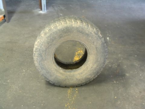 1994 Jeep YJ - A single tire is shown resting on a dusty concrete floor, possibly in a garage or workshop.