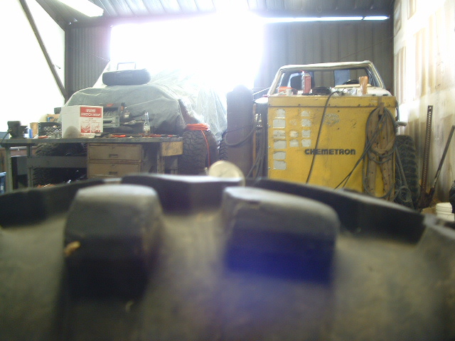 Jeep CJ-7 interior, close-up on dashboard and windshield frame, with a yellow Chemtron machine in the background