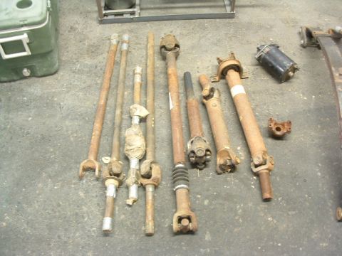 1994 Jeep YJ - Collection of driveshafts and a starter motor, likely for automotive repair or restoration.