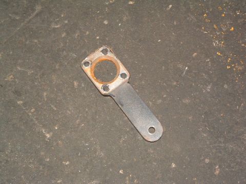 1994 Jeep YJ - This metal bracket with a circular opening and mounting holes is shown against a dark, textured surface.