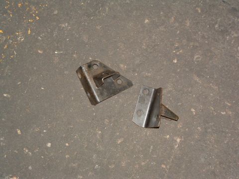 1994 Jeep YJ - Two metal brackets are shown on a gray concrete surface.