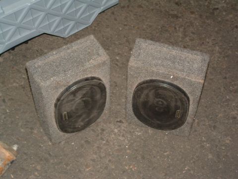 1994 Jeep YJ - Two speaker boxes are shown on a concrete floor, with a grey textured object in the upper left.
