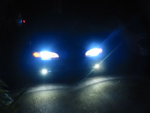 1995 Ford Thunderbird - Headlights on a dark road at night.