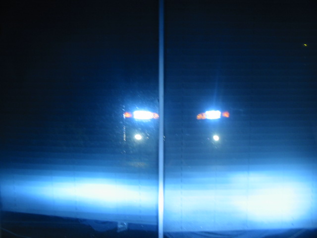Two vehicles at night, headlights illuminated. Watermark reads SUPERMOTORS