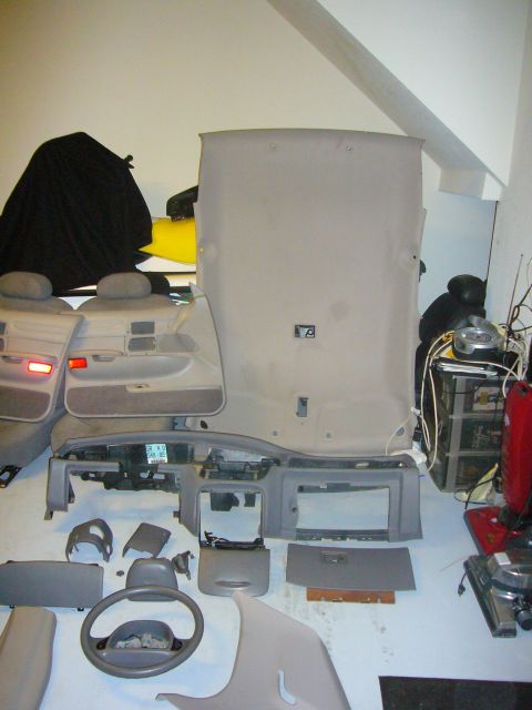 2000 Ford Crown Victoria - Various interior components are laid out, suggesting a vehicle is being dismantled or repaired.