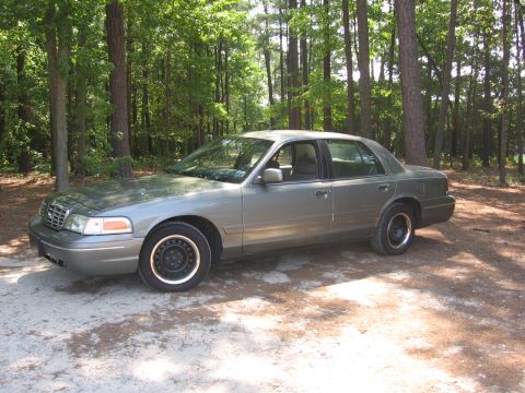 2000 Ford Crown Victoria - Side view of a 2000 Ford Crown Victoria parked outdoors among trees.