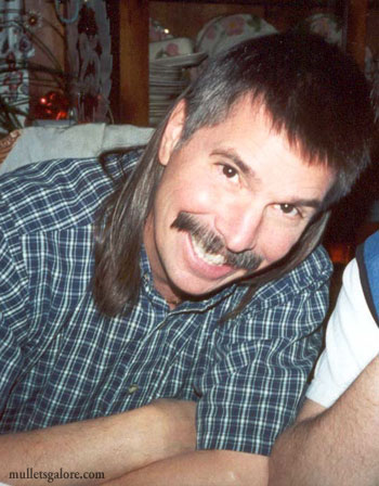 1973 Ford Ranchero - A man with a distinctive mullet and mustache smiles for the camera while wearing a blue and white plaid shirt.
