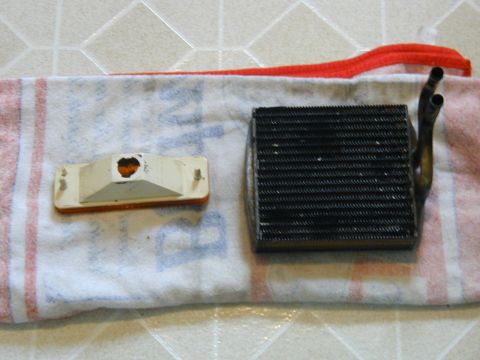 1986 Ford Bronco - A car's heater core and a front turn signal light are shown resting on a towel.