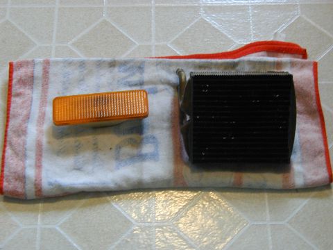 1986 Ford Bronco - An orange turn signal and a black radiator are laid out on a towel.