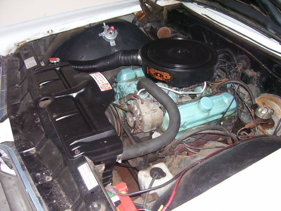 Turquoise-painted Pontiac V8 with black snorkel air cleaner in a white car's engine bay
