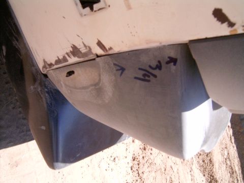 1978 Ford Mustang II - Close-up of a dark blue body panel resting on dirt, its lower section sanded to bare metal and marked in blue marker with '3/4' and two arr…