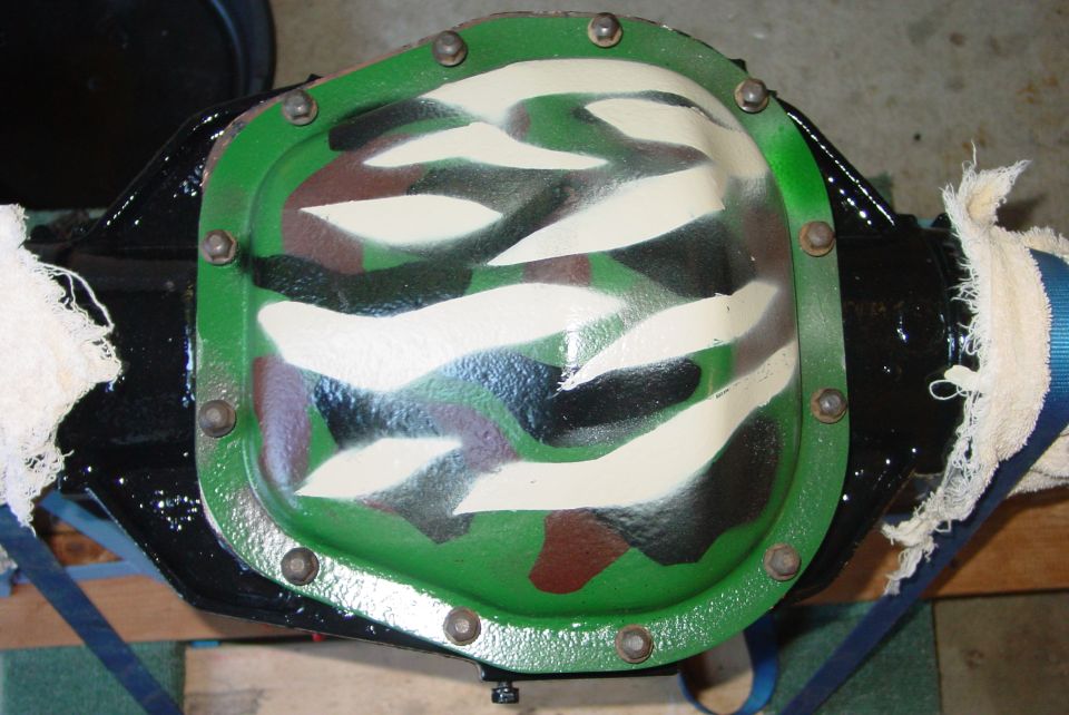 Differential cover with green, white, black, and brown camouflage paint