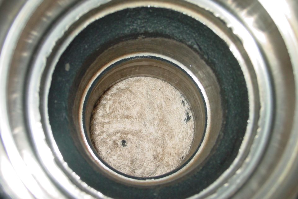 Inside view of a metal pipe with fuzzy material at the bottom, Supermotors logo visible