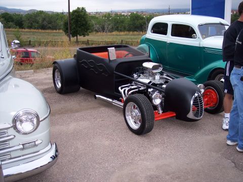 1972 Ford Ranchero - A custom hot rod is parked next to a classic sedan at an outdoor event.