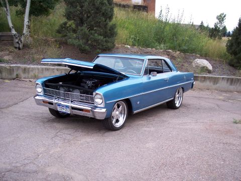 1972 Ford Ranchero - A blue classic coupe is parked outdoors with its hood raised, revealing the engine compartment.
