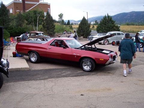 1972 Ford Ranchero - A red 1972 Ford Ranchero is parked with its hood open, displaying the engine bay.