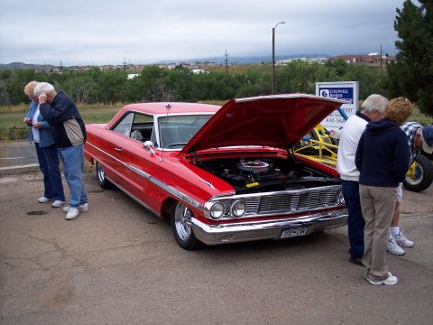 1972 Ford Ranchero - People look at a red 1963 Ford Galaxie coupe with its hood open.