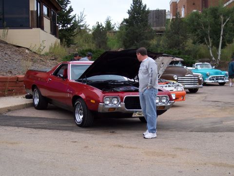 1972 Ford Ranchero - A red 1972 Ford Ranchero is displayed with its hood open, alongside other vintage vehicles.