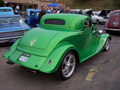 1972 Ford Ranchero - A bright green custom coupe with flame decals sits parked at an outdoor event with other vehicles.