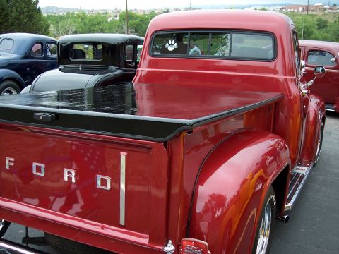 1972 Ford Ranchero - A classic red Ford pickup truck is parked next to other vintage vehicles.