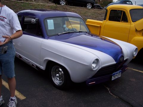 1972 Ford Ranchero - A custom two-tone purple and white coupe with flame decals is parked next to a yellow pickup truck.