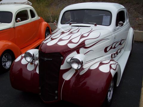 1972 Ford Ranchero - Custom hot rod with flame paint job, parked alongside another classic vehicle.